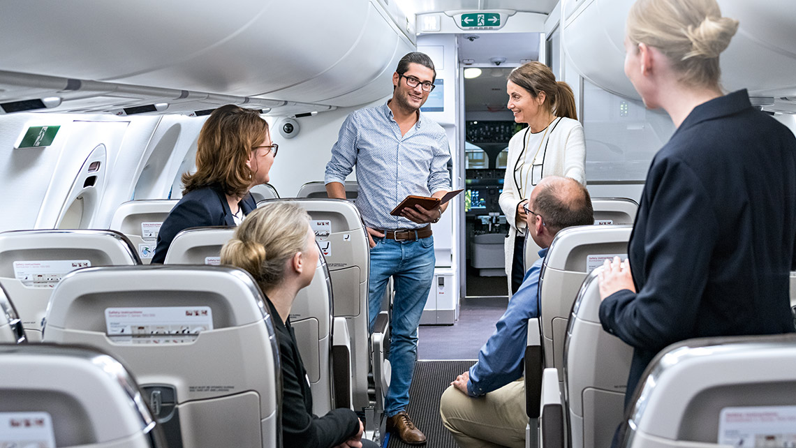 mehrere Personen stehen und sitzen in einem Flugzeug